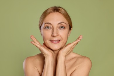 Photo of Portrait of smiling woman with healthy skin on green background