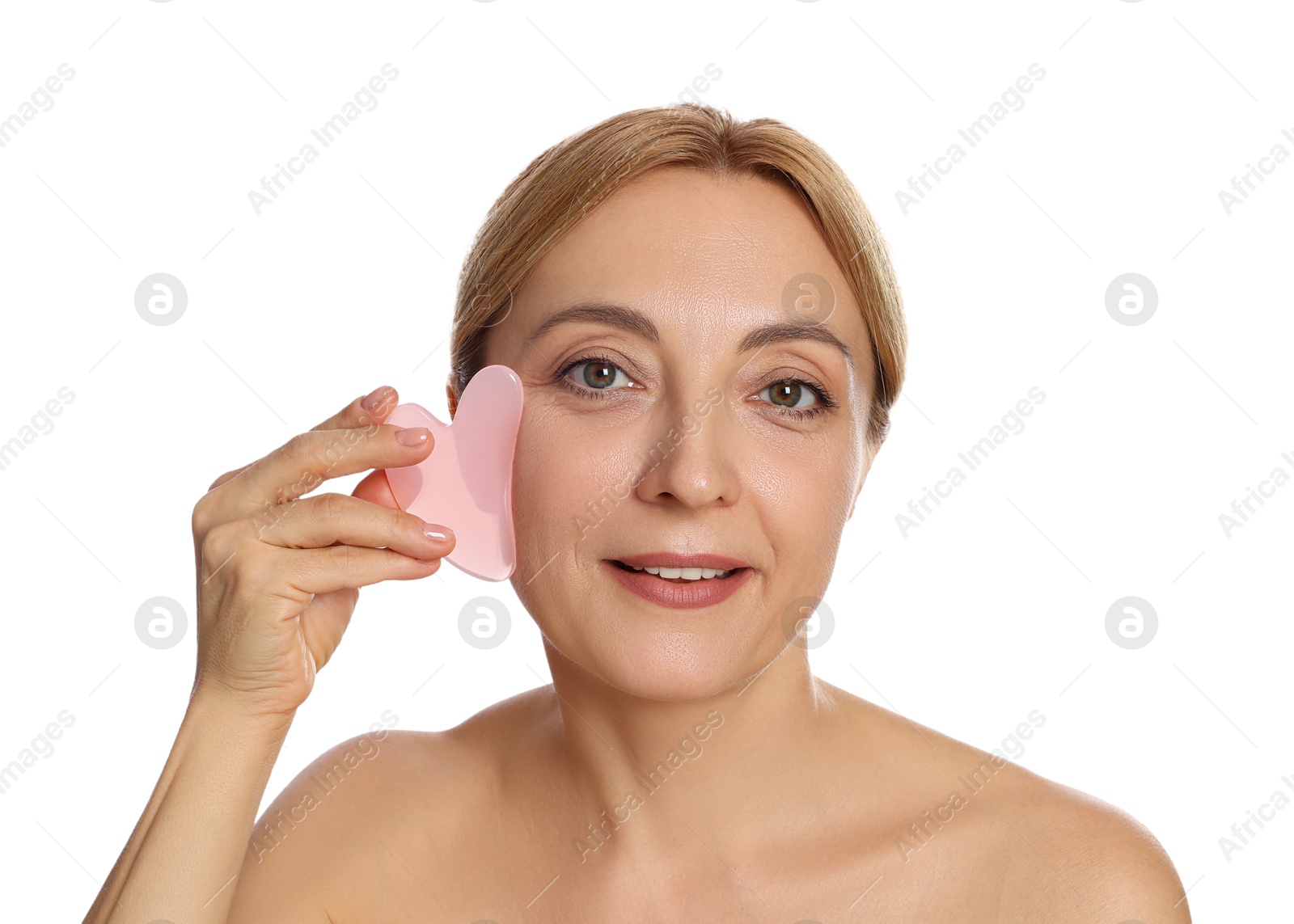 Photo of Smiling woman doing facial self massage with gua sha tool on white background