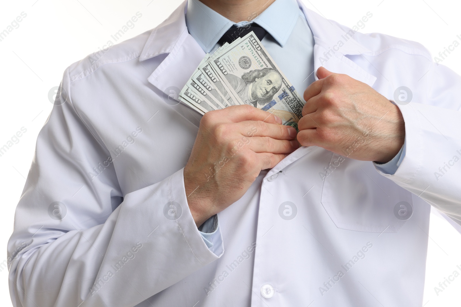 Photo of Corruption concept. Doctor putting dollar banknotes into his coat on white background, closeup