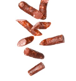 Image of Dry smoked sausage pieces in air on white background, collage