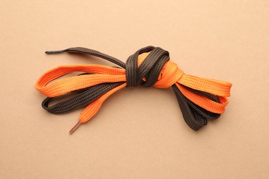 Photo of Shoelaces tied in knot on beige background, top view. Unity concept