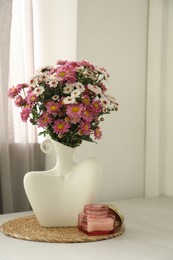 Photo of Stylish vase with beautiful flowers and candle on white wooden table