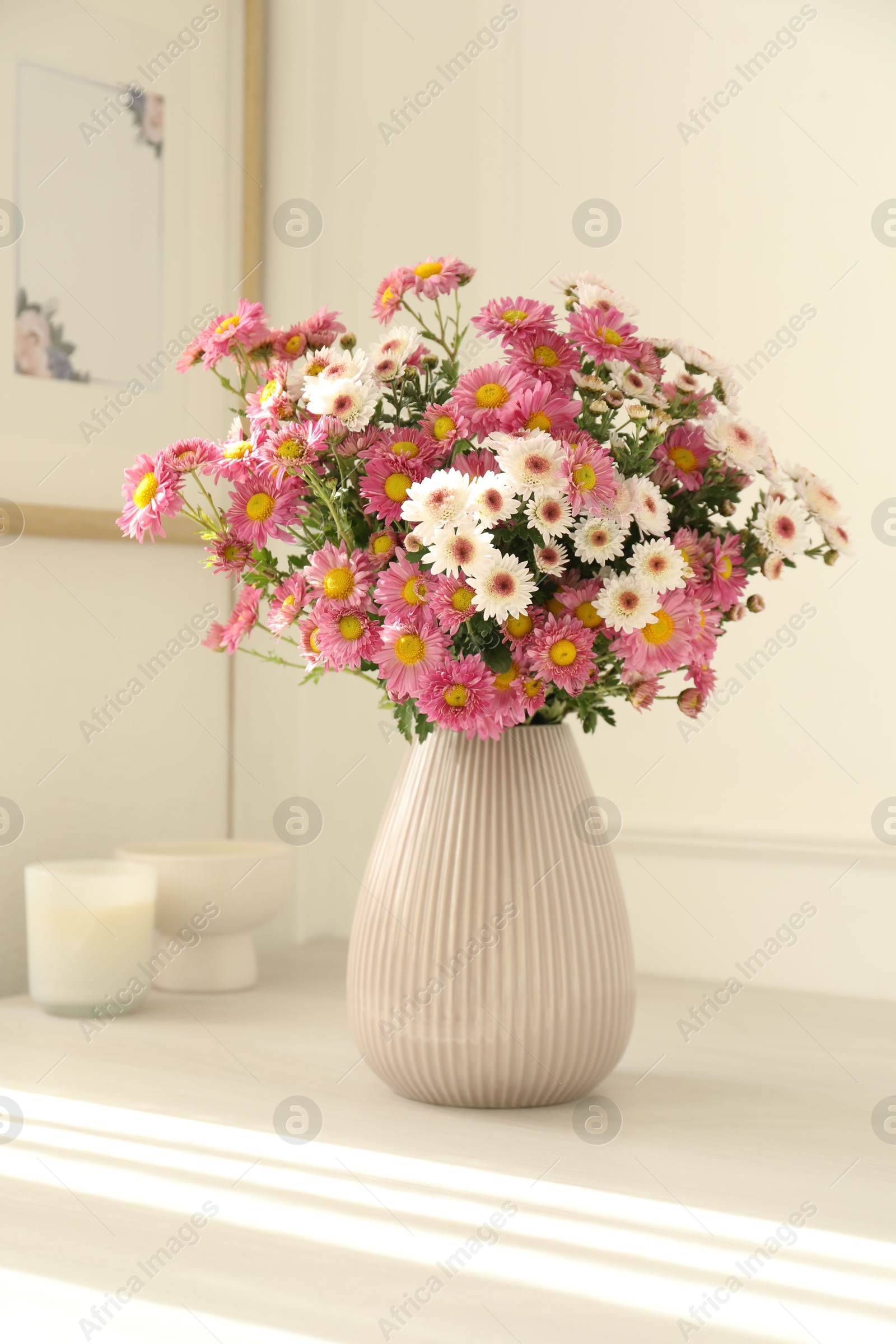 Photo of Beautiful flowers in vase and decor on white table at home