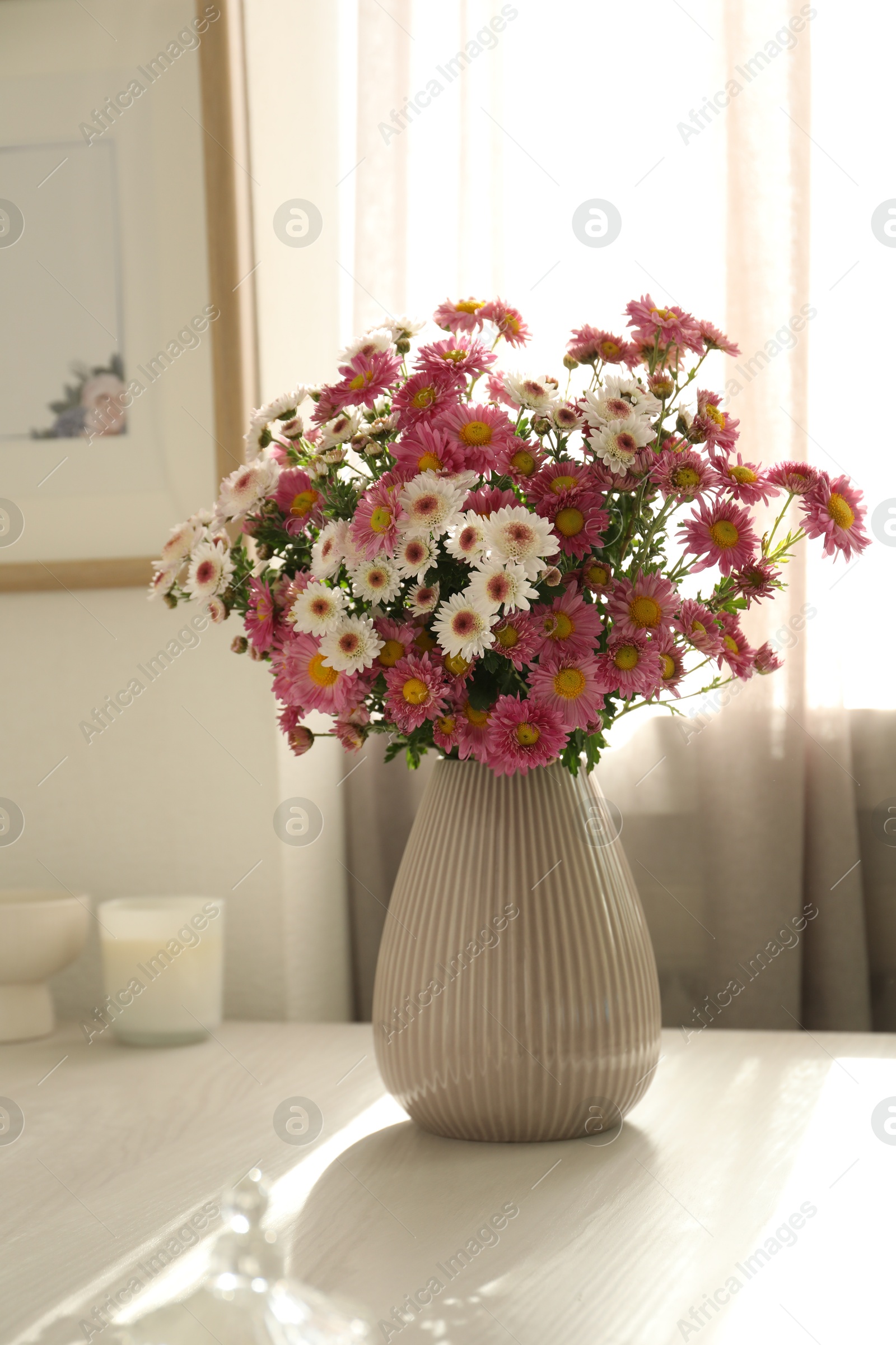 Photo of Beautiful flowers in vase and decor on white table at home