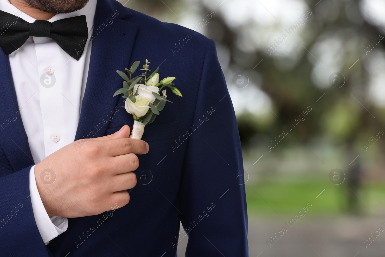 Image of Groom with boutonniere outdoors, closeup. Wedding accessory