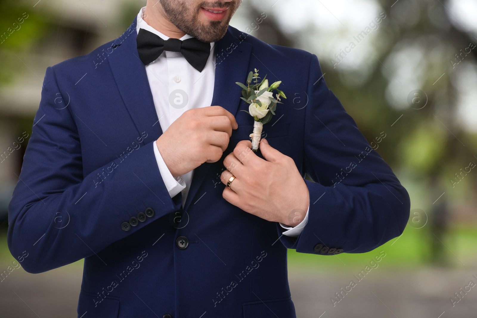 Image of Groom with boutonniere outdoors, closeup. Wedding accessory