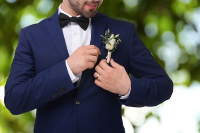 Image of Groom with boutonniere outdoors, closeup. Wedding accessory