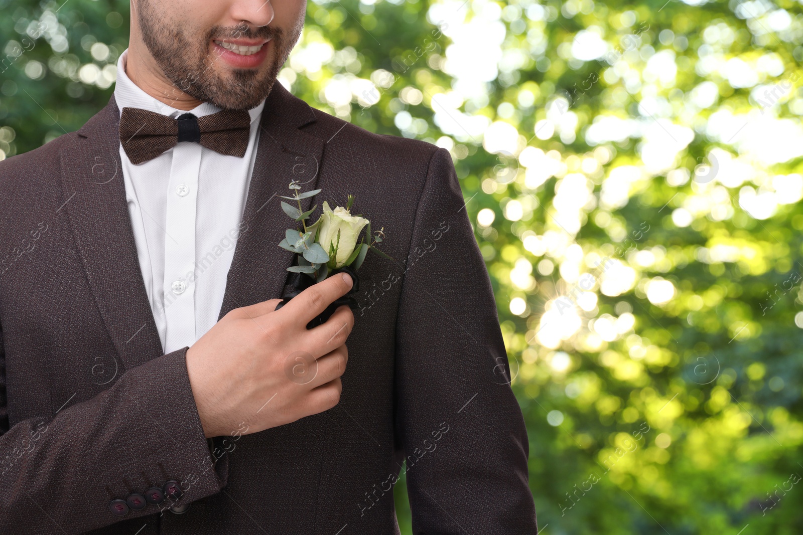 Image of Groom with boutonniere outdoors, closeup. Wedding accessory