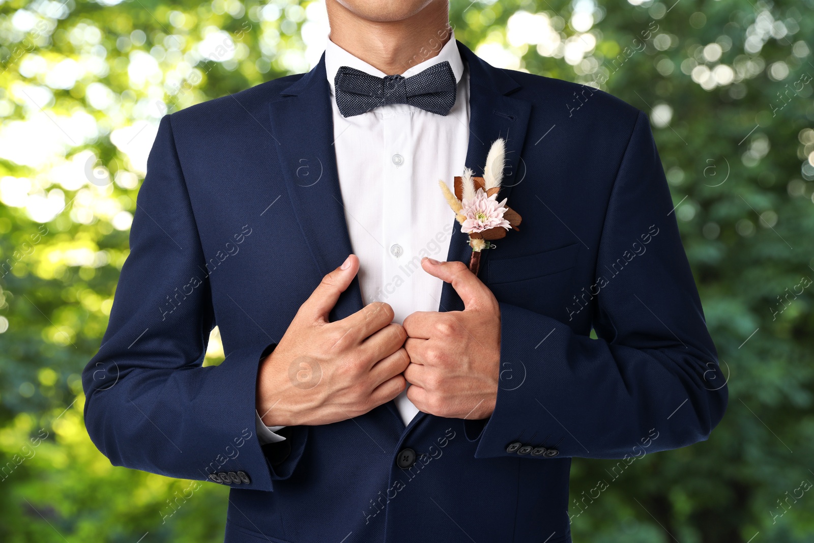 Image of Groom with boutonniere outdoors, closeup. Wedding accessory