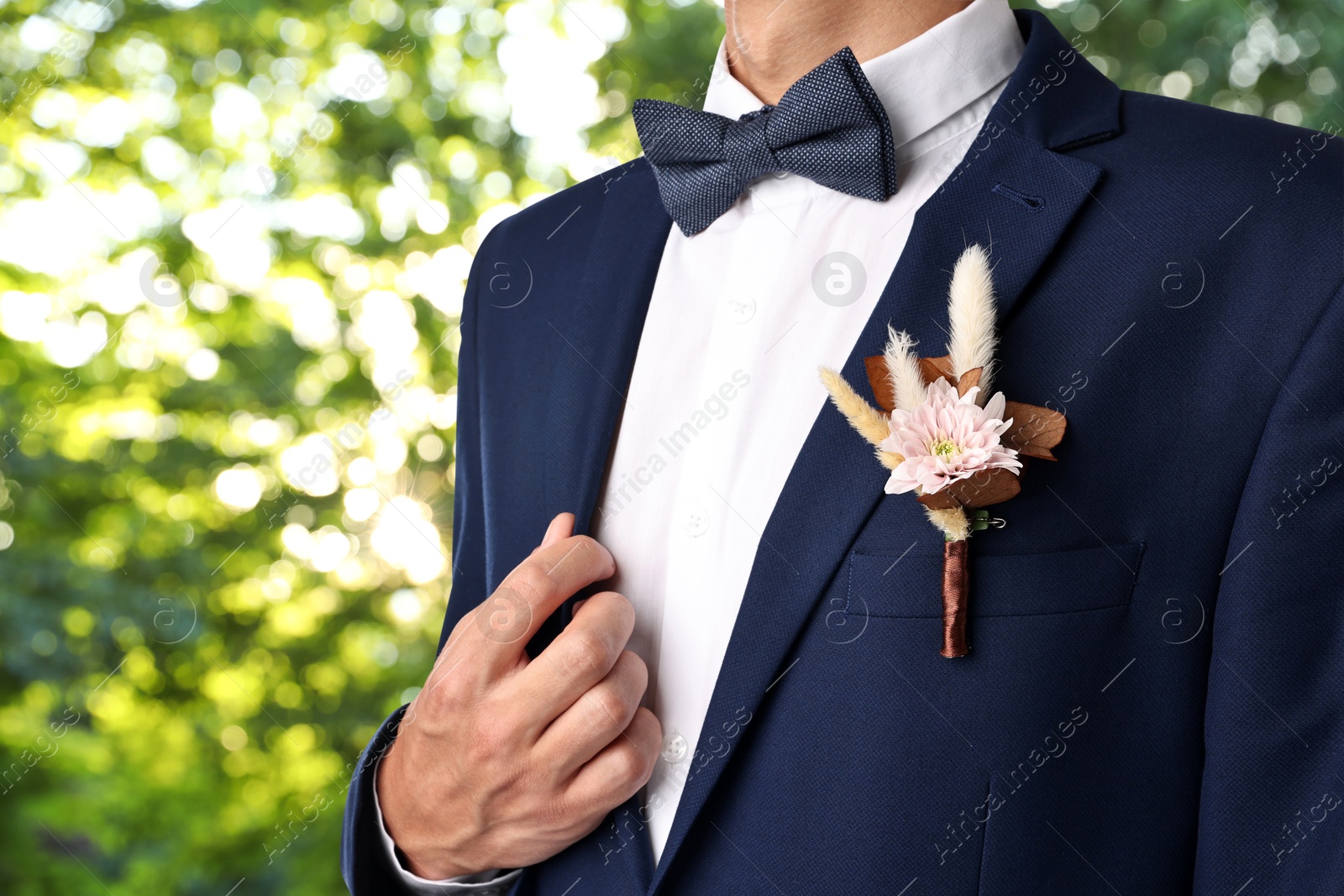 Image of Groom with boutonniere outdoors, closeup. Wedding accessory