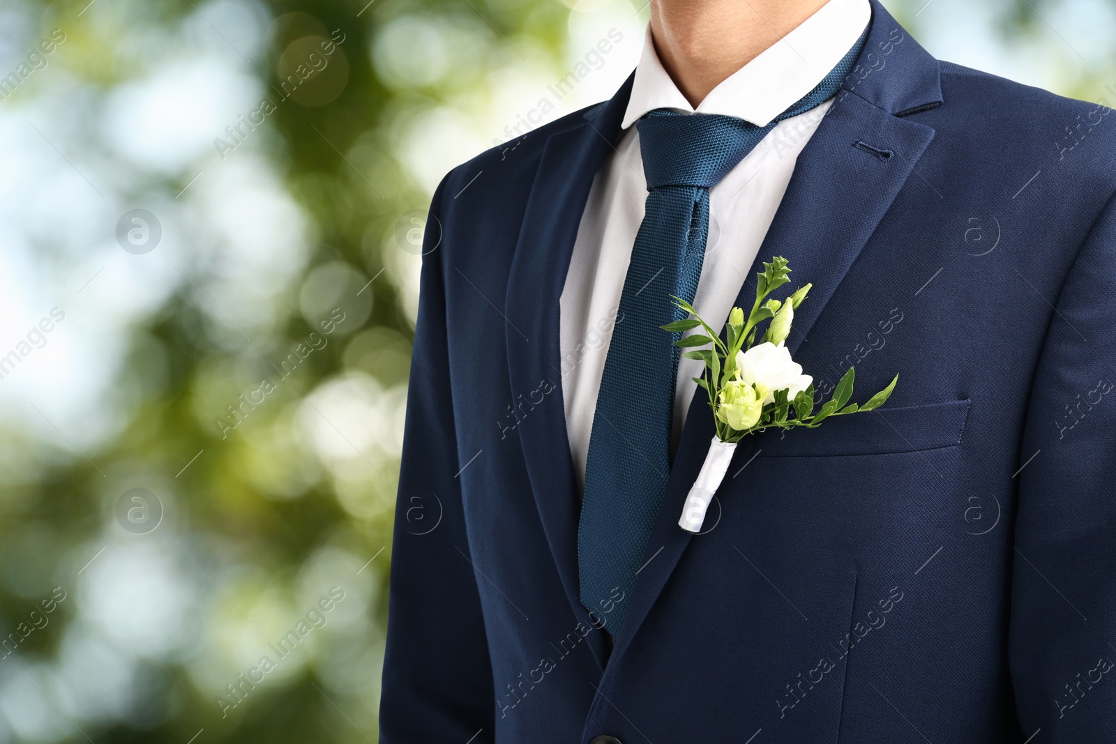 Image of Groom with boutonniere outdoors, closeup. Wedding accessory