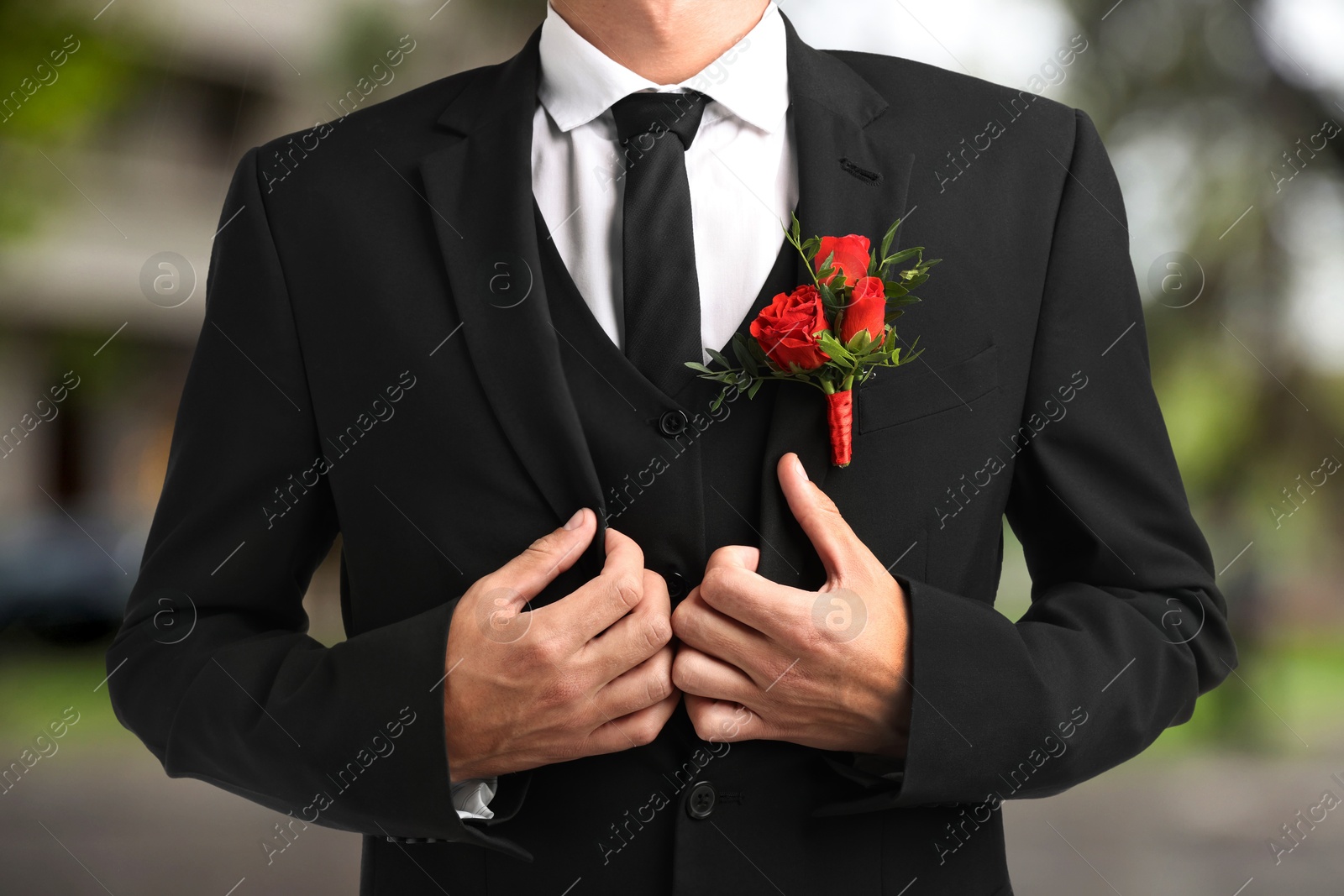 Image of Groom with boutonniere outdoors, closeup. Wedding accessory