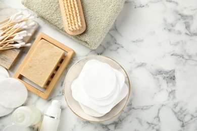 Photo of Flat lay composition with cotton pads on light marble table, space for text