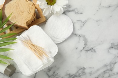 Photo of Flat lay composition with cotton pads on light marble table, space for text