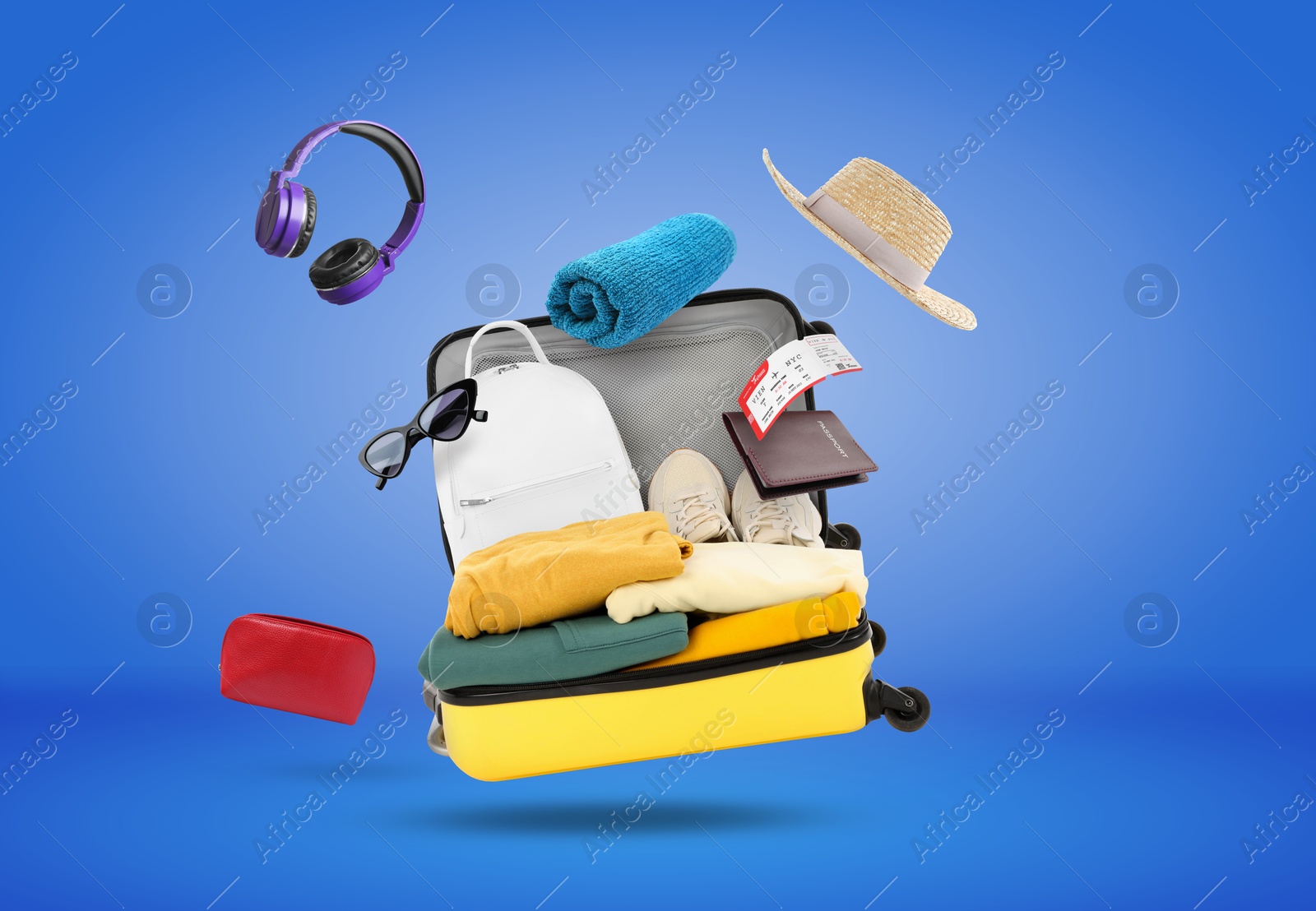 Image of Suitcase, clothes and other items in air on blue background. Ready to travel