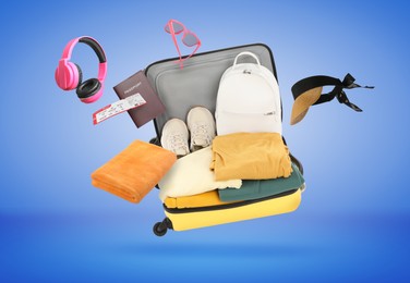 Image of Suitcase, clothes and other items in air on blue background. Ready to travel