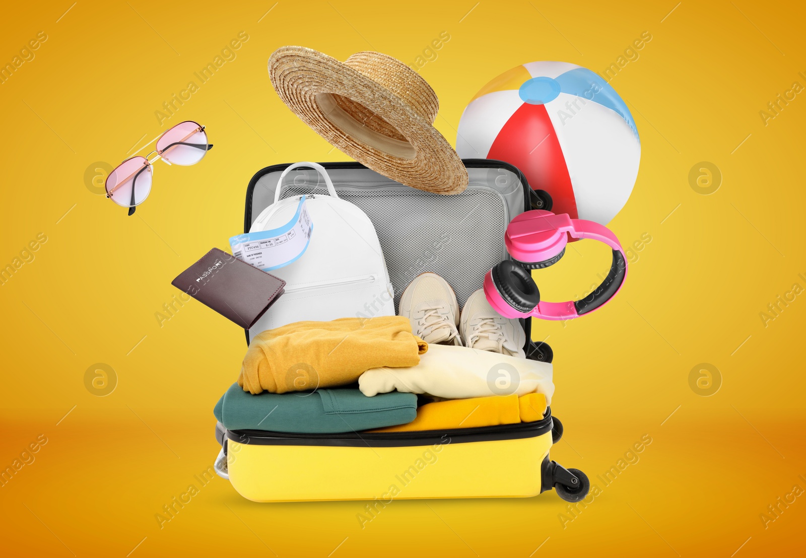 Image of Suitcase with clothes and other flying items on orange background. Ready to travel