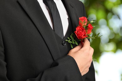 Image of Groom with boutonniere outdoors, closeup. Wedding accessory