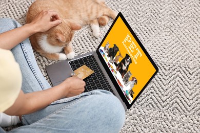 Image of Woman with her cute cat shopping online on laptop at home, closeup. Computer with open pet shop website