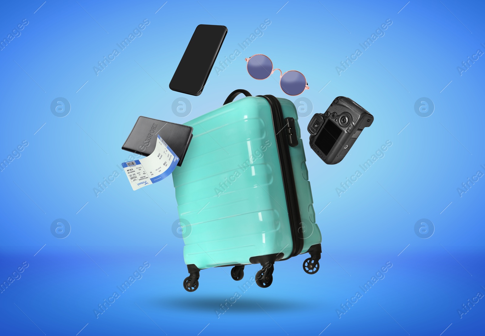 Image of Suitcase, passport, ticket, smartphone, sunglasses and camera in air on blue background. Ready to travel