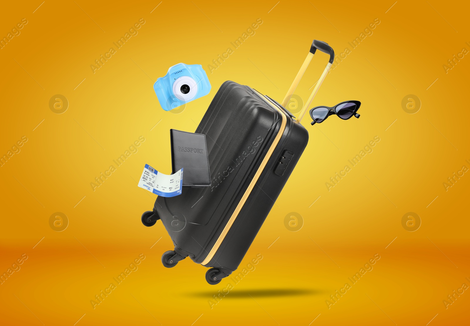 Image of Suitcase, passport, ticket, sunglasses and camera in air on orange background. Ready to travel