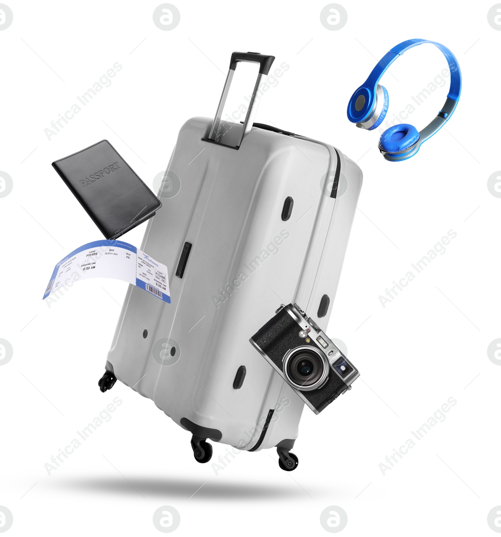 Image of Suitcase, passport, ticket, headphones and camera in air on white background. Ready to travel