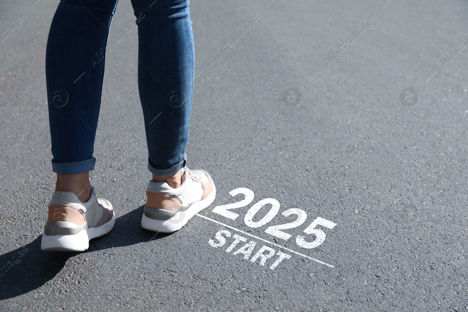 Image of Woman walking near sign 2025 Start on asphalt, closeup. Concept of new year, fresh beginning