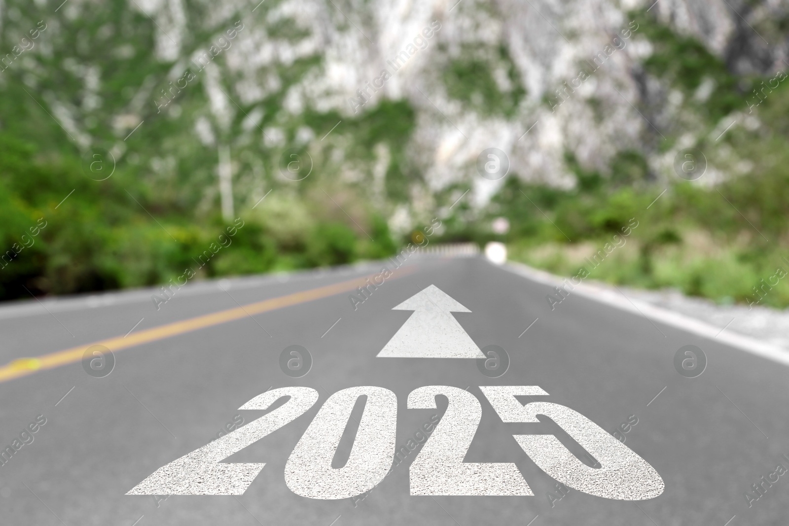 Image of 2025 and arrow on asphalt road in mountains. Concept of new year, fresh beginning