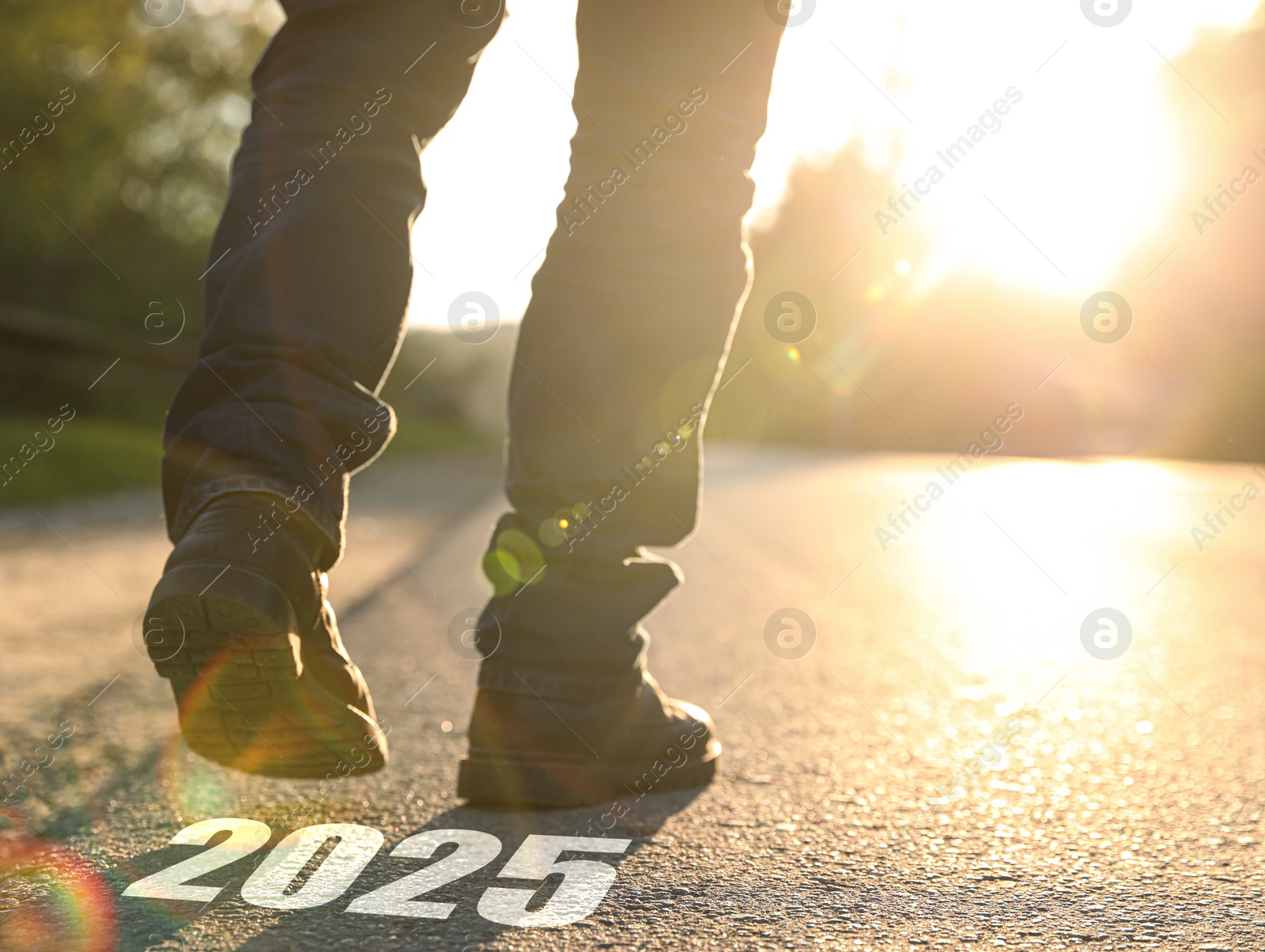 Image of Man walking near sign 2025 on asphalt, closeup. Concept of new year, fresh beginning