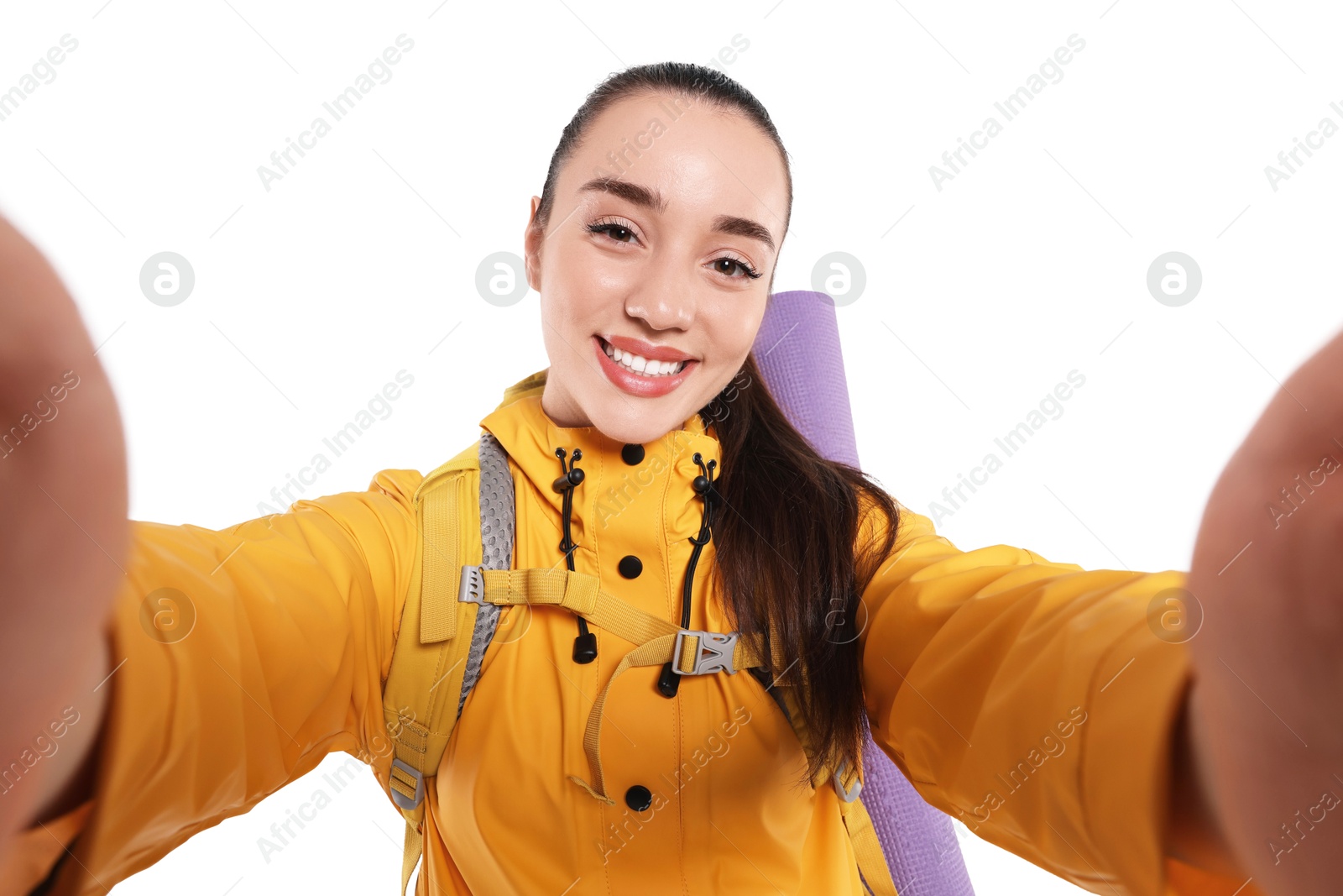 Photo of Smiling young woman with backpack taking selfie on white background. Active tourism