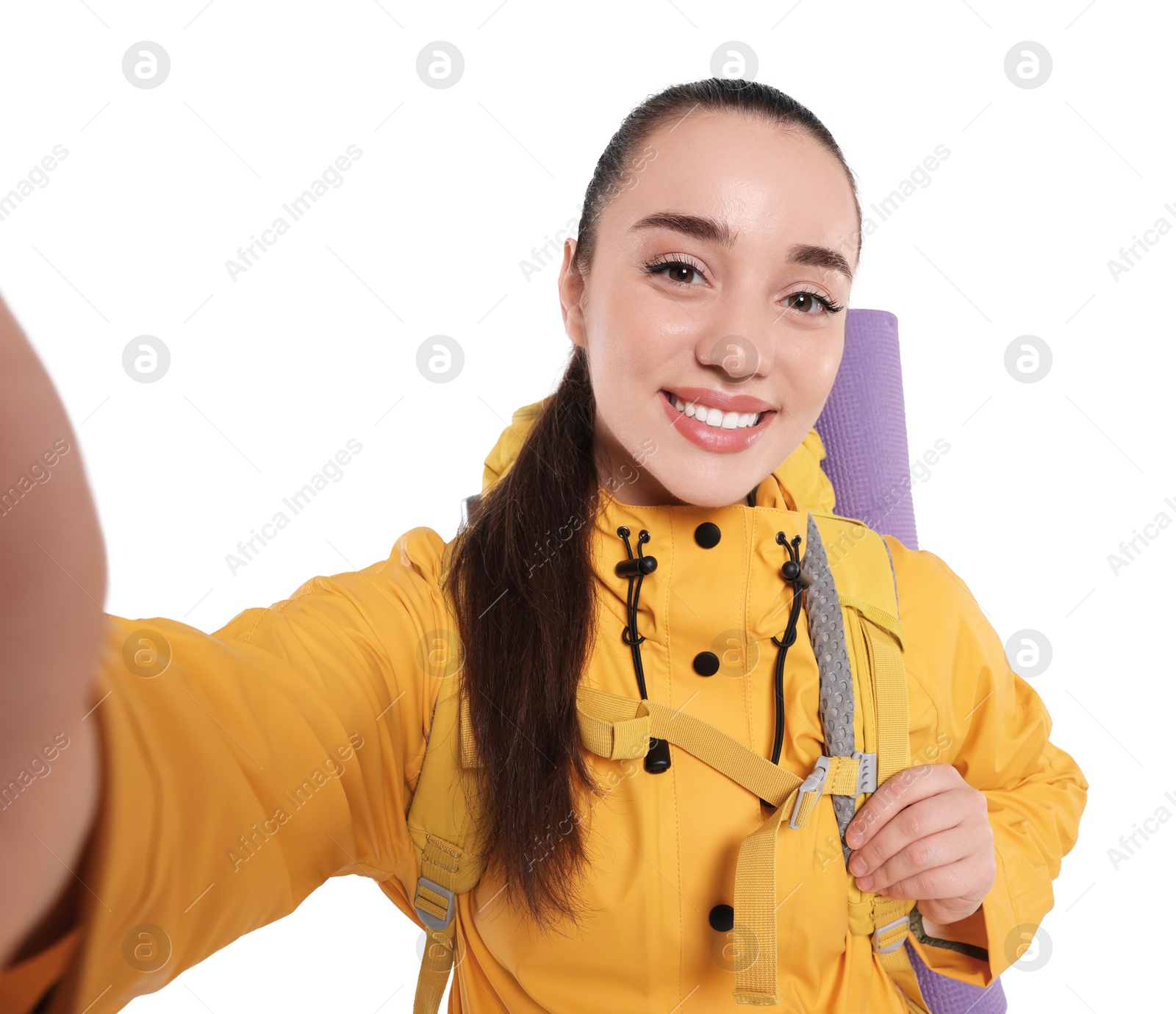 Photo of Smiling young woman with backpack taking selfie on white background. Active tourism