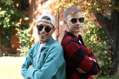 Family portrait of happy brothers with crossed arms outdoors