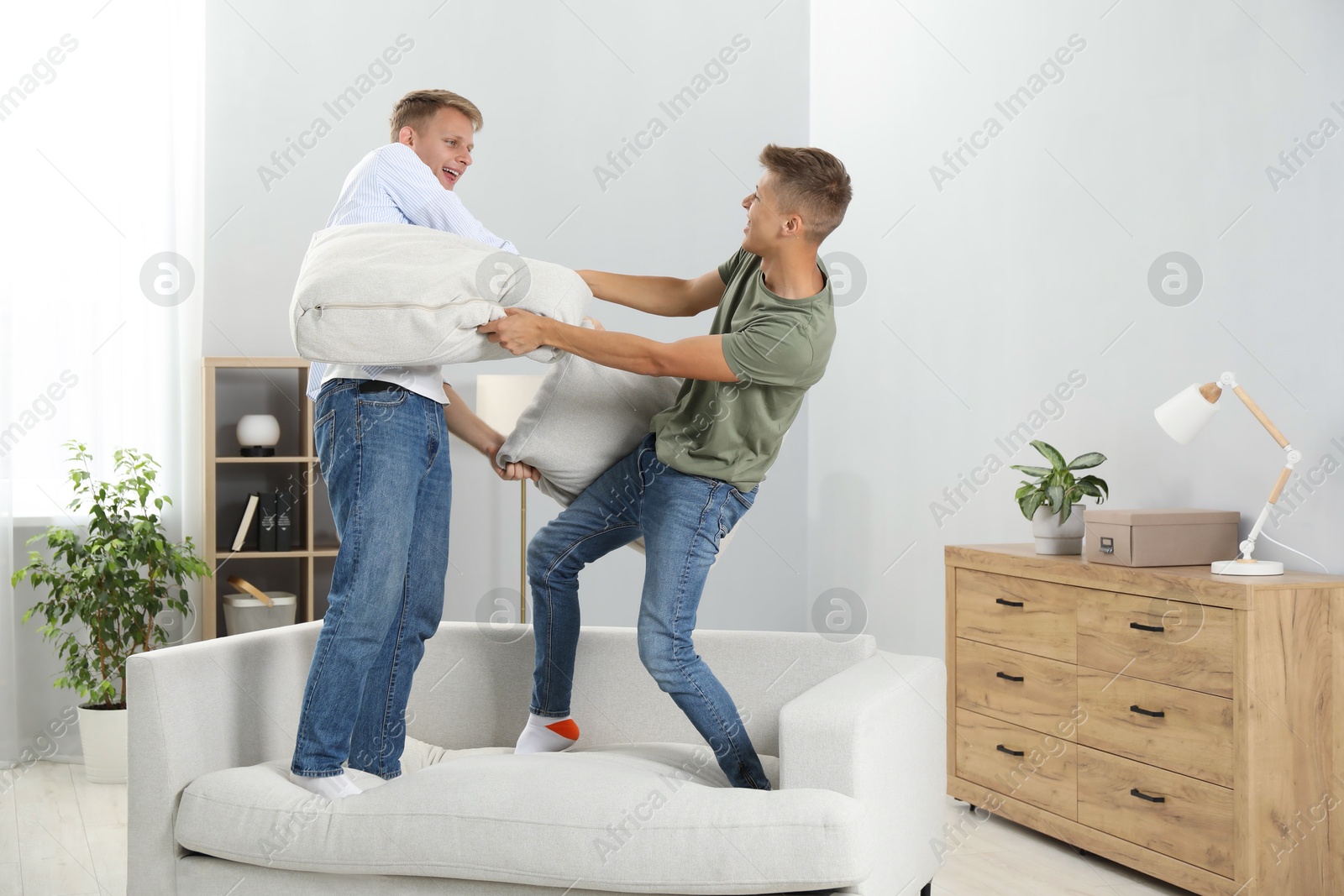 Photo of Happy brothers having pillow fight at home