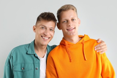 Portrait of two happy brothers on light background