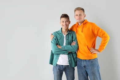 Two happy brothers posing on light background. Space for text