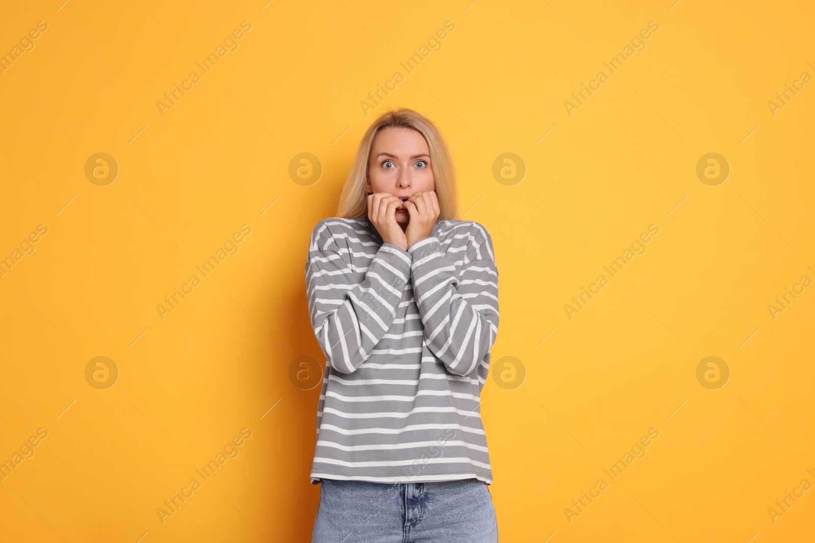 Photo of Portrait of scared woman on orange background