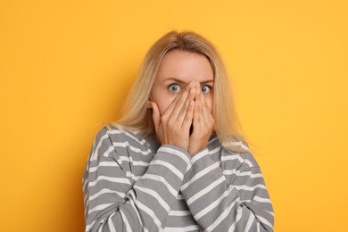 Photo of Portrait of scared woman on orange background