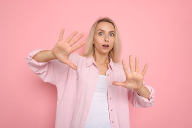 Photo of Portrait of scared woman on pink background