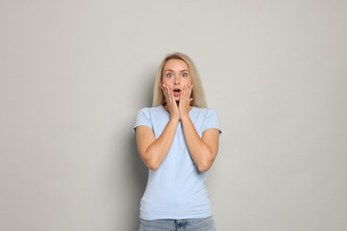 Portrait of scared woman on gray background