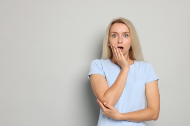 Photo of Portrait of scared woman on gray background, space for text