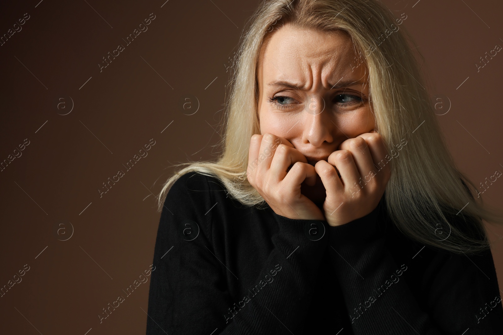 Photo of Portrait of scared woman on brown background