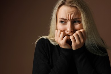 Portrait of scared woman on brown background