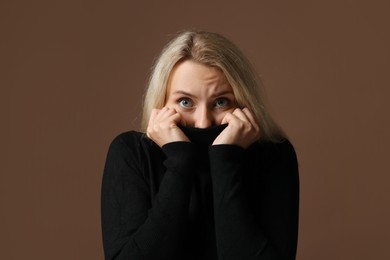 Photo of Portrait of scared woman on brown background