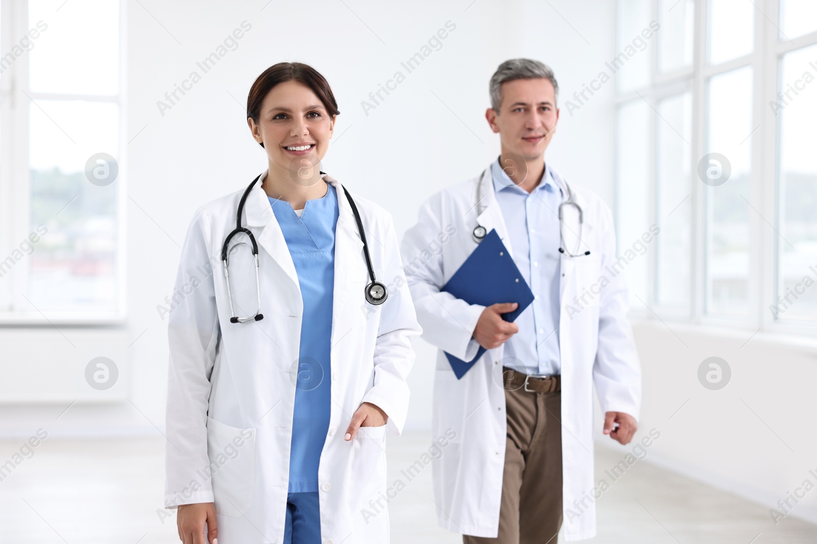 Photo of Healthcare workers with stethoscope and clipboard in hospital, selective focus