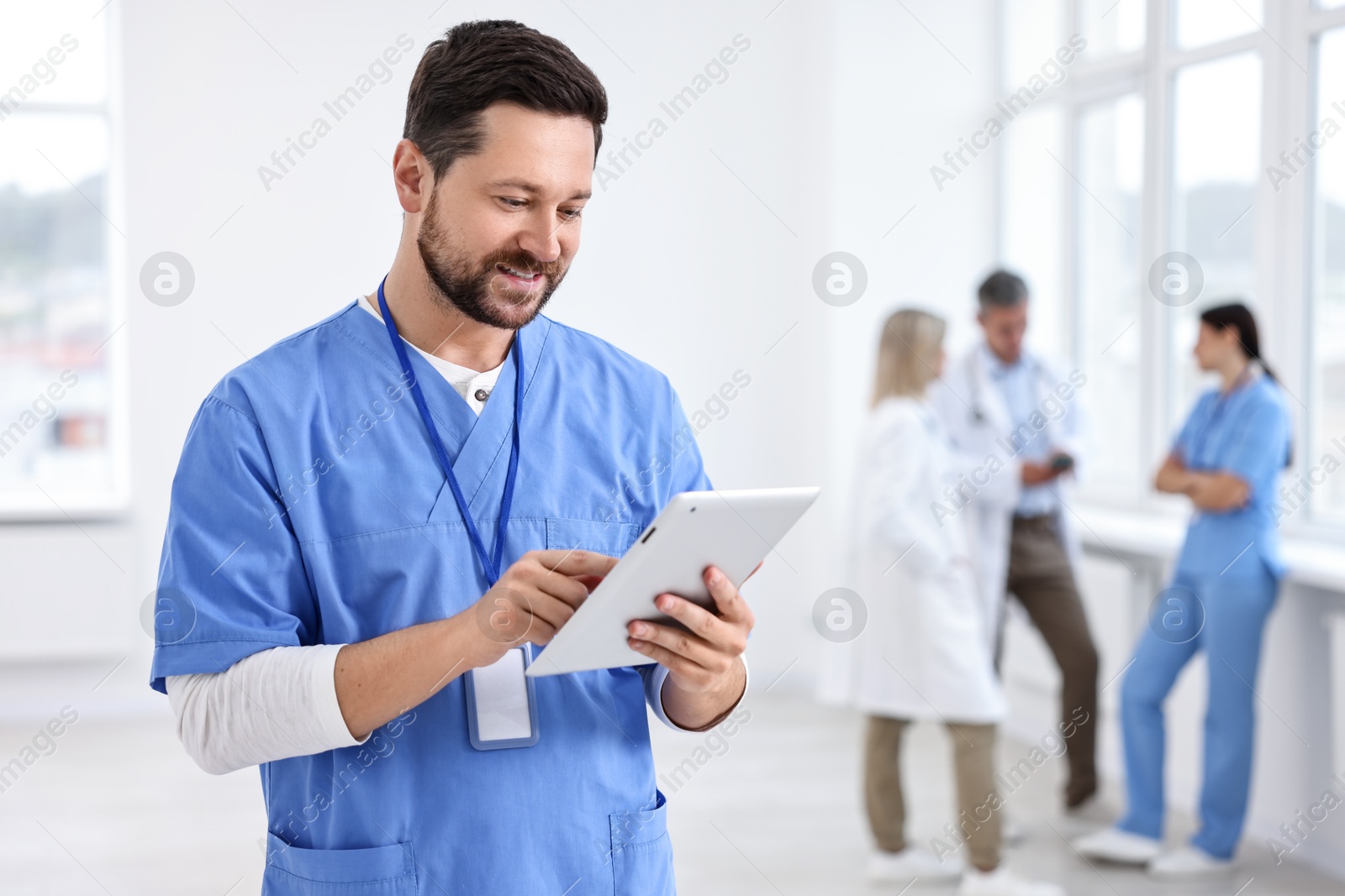 Photo of Healthcare workers in hospital, selective focus. Nurse with tablet indoors