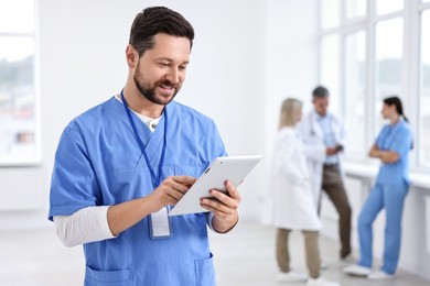 Photo of Healthcare workers in hospital, selective focus. Nurse with tablet indoors