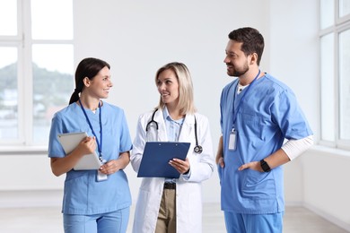 Photo of Group of healthcare workers with clipboard and tablet in hospital