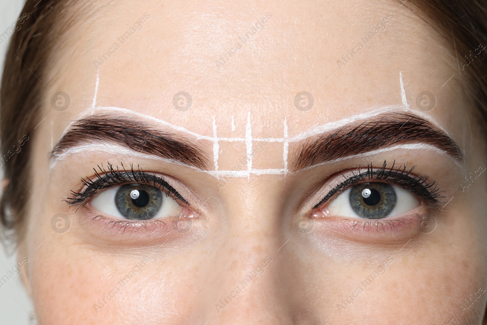 Photo of Young woman during henna eyebrows dyeing procedure, closeup