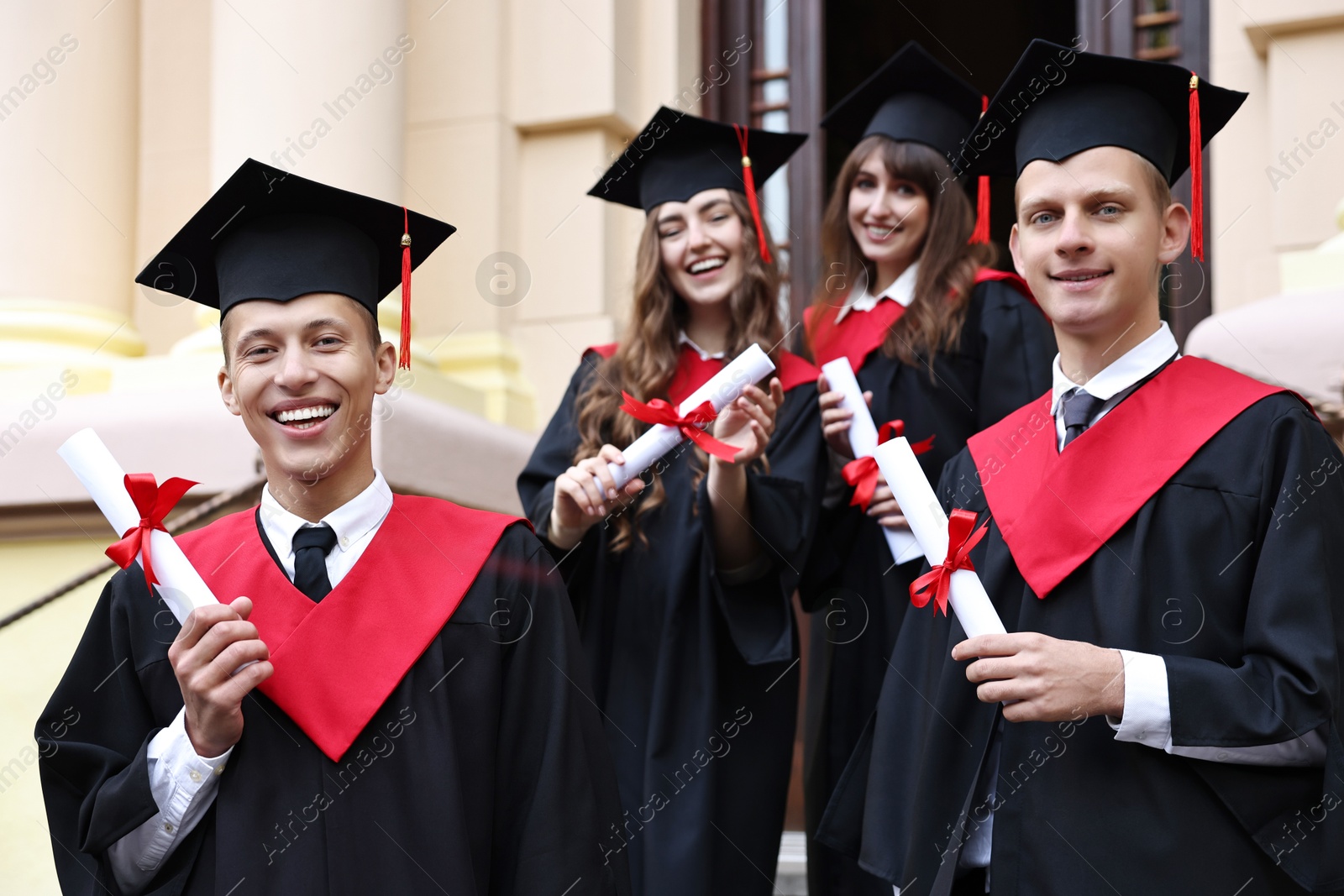 Photo of Graduation ceremony. Happy students with diplomas outdoors, selective focus