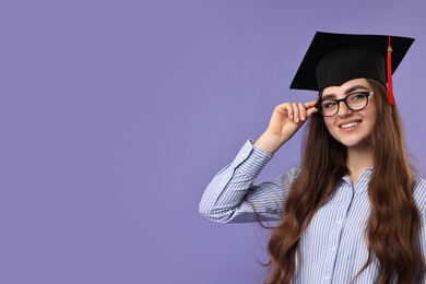 Photo of Happy student after graduation on violet background. Space for text